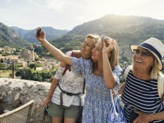 Multi generation group sightseeing beautiful town of Valldemossa, Spain - Journey House Travel