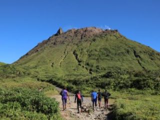 People hike the summit trail to La Soufriere volcano in Caribbean French island of Guadeloupe - Journey House Travel