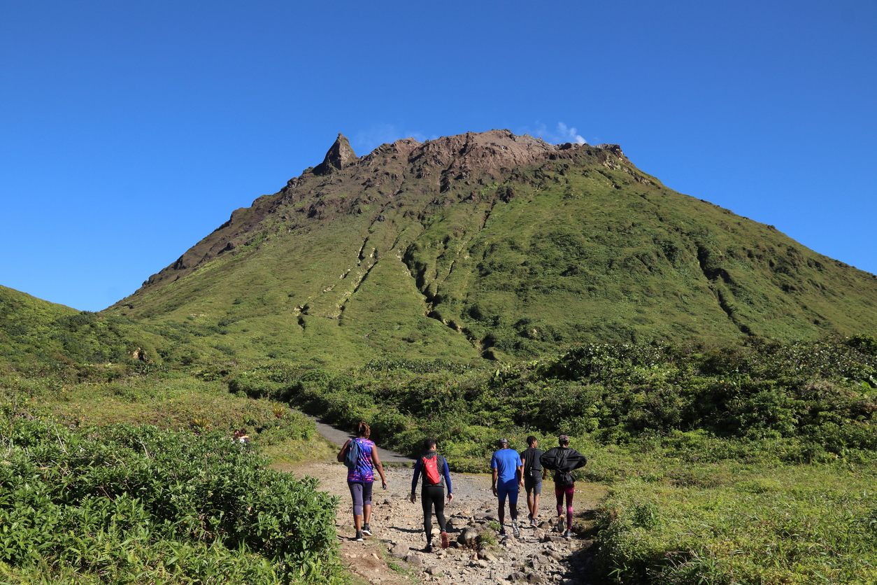 People hike the summit trail to La Soufriere volcano in Caribbean French island of Guadeloupe - Journey House Travel